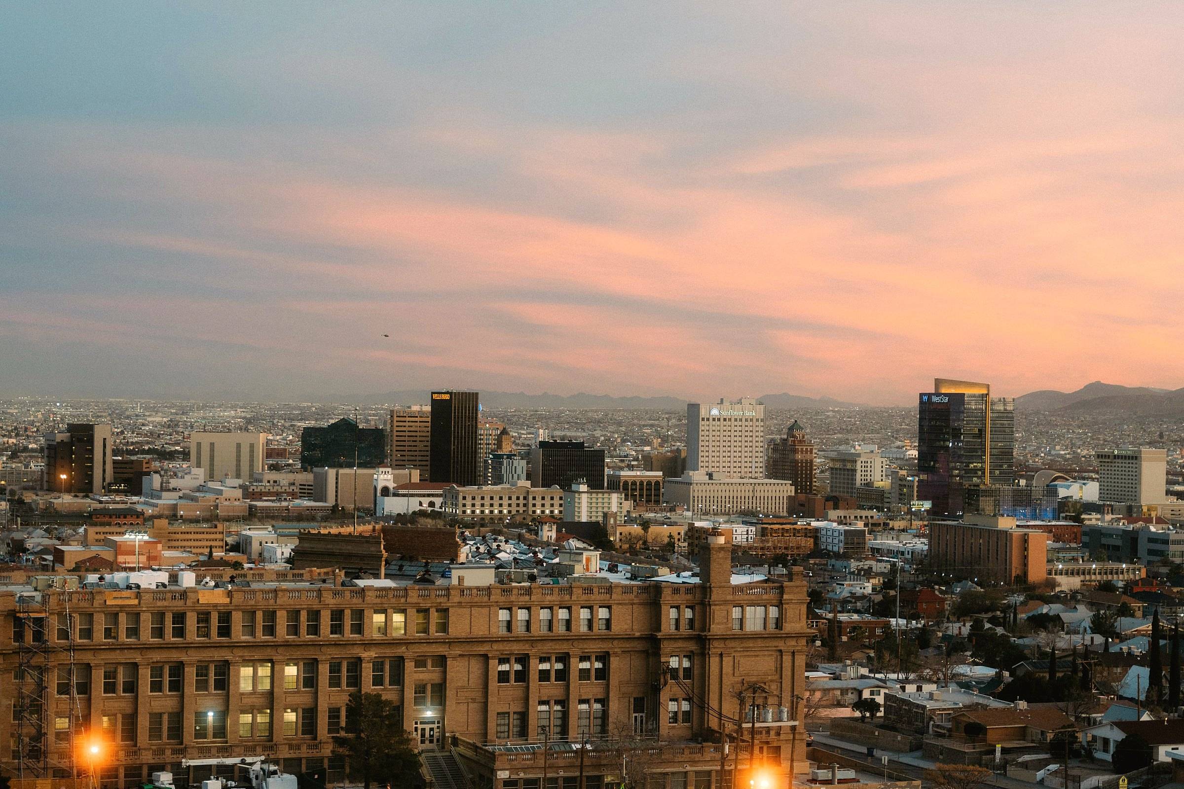 Downtown El Paso at dusk under pink clouds, El Paso High School in the foreground
