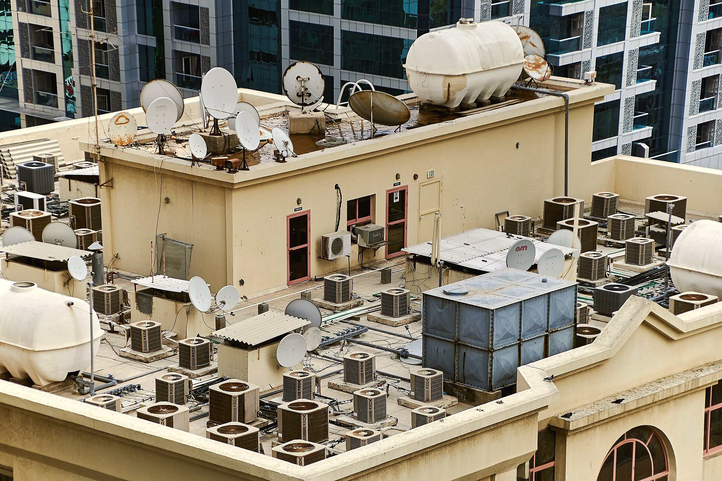 Dozens of air-conditioning units crowded on a building rooftop