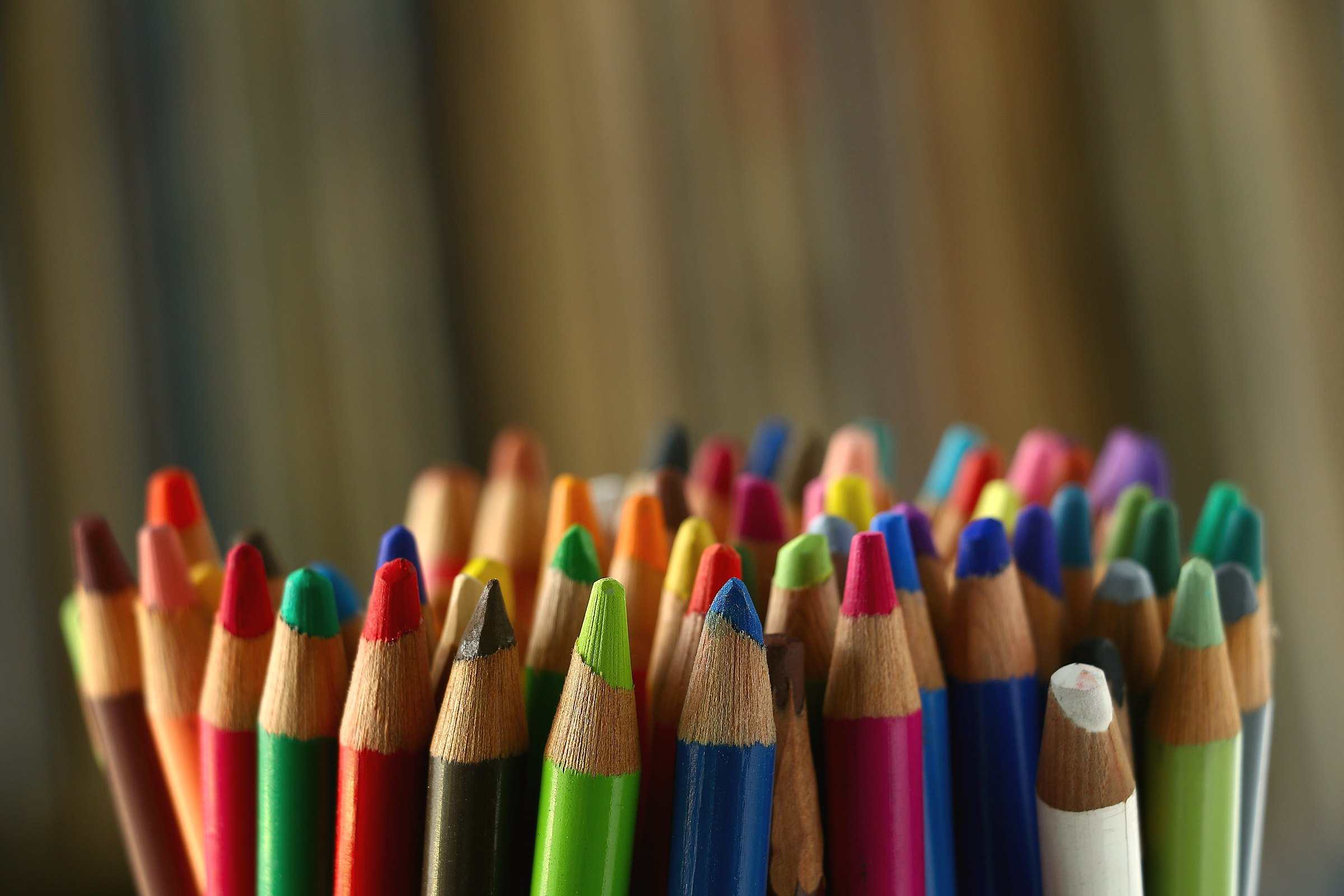 A bundle of sharpened colored pencils against a dark background