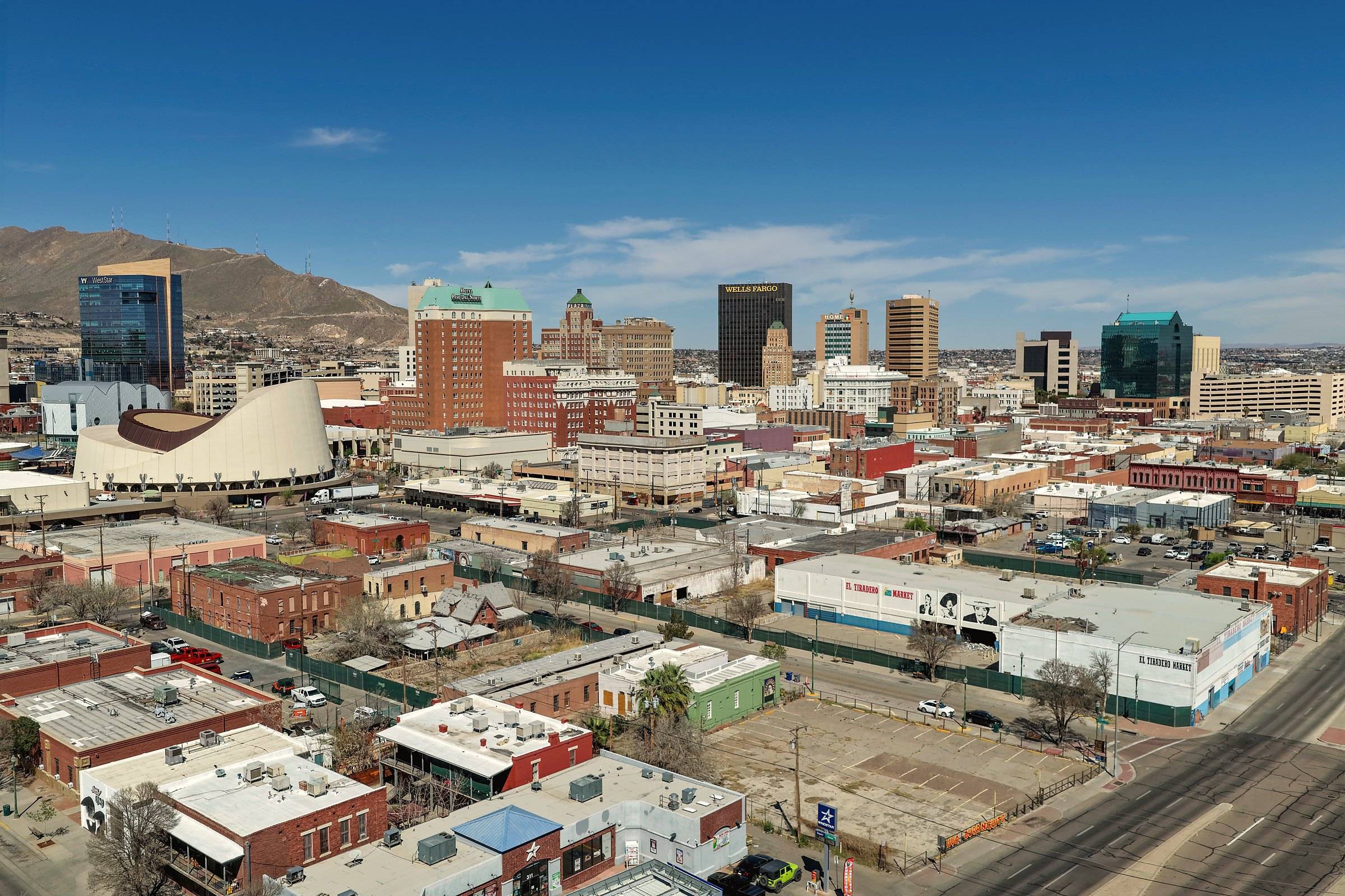The towers of downtown El Paso under a blue sky, with mountains beyond