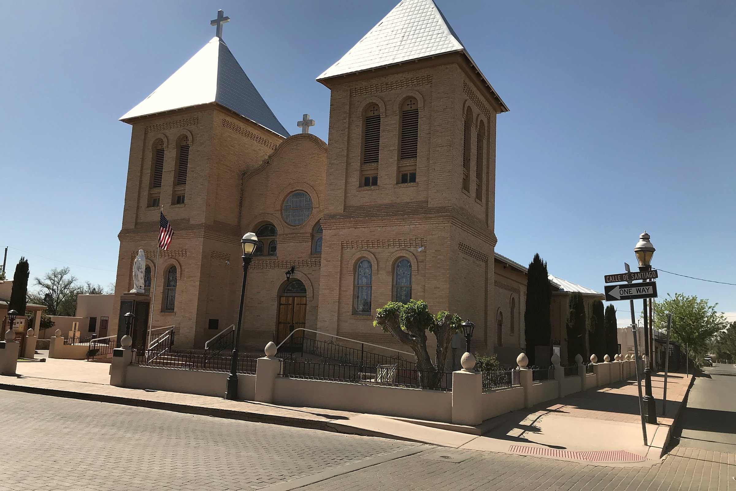The twin bell towers of the Basilica of San Albino in Mesilla, New Mexico, against a blue sky