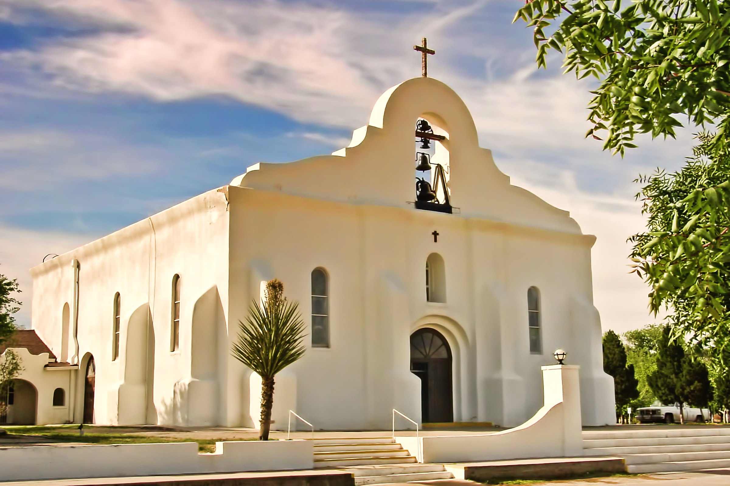 The white Presidio Chapel of San Elizario, Texas, in warm afternoon light