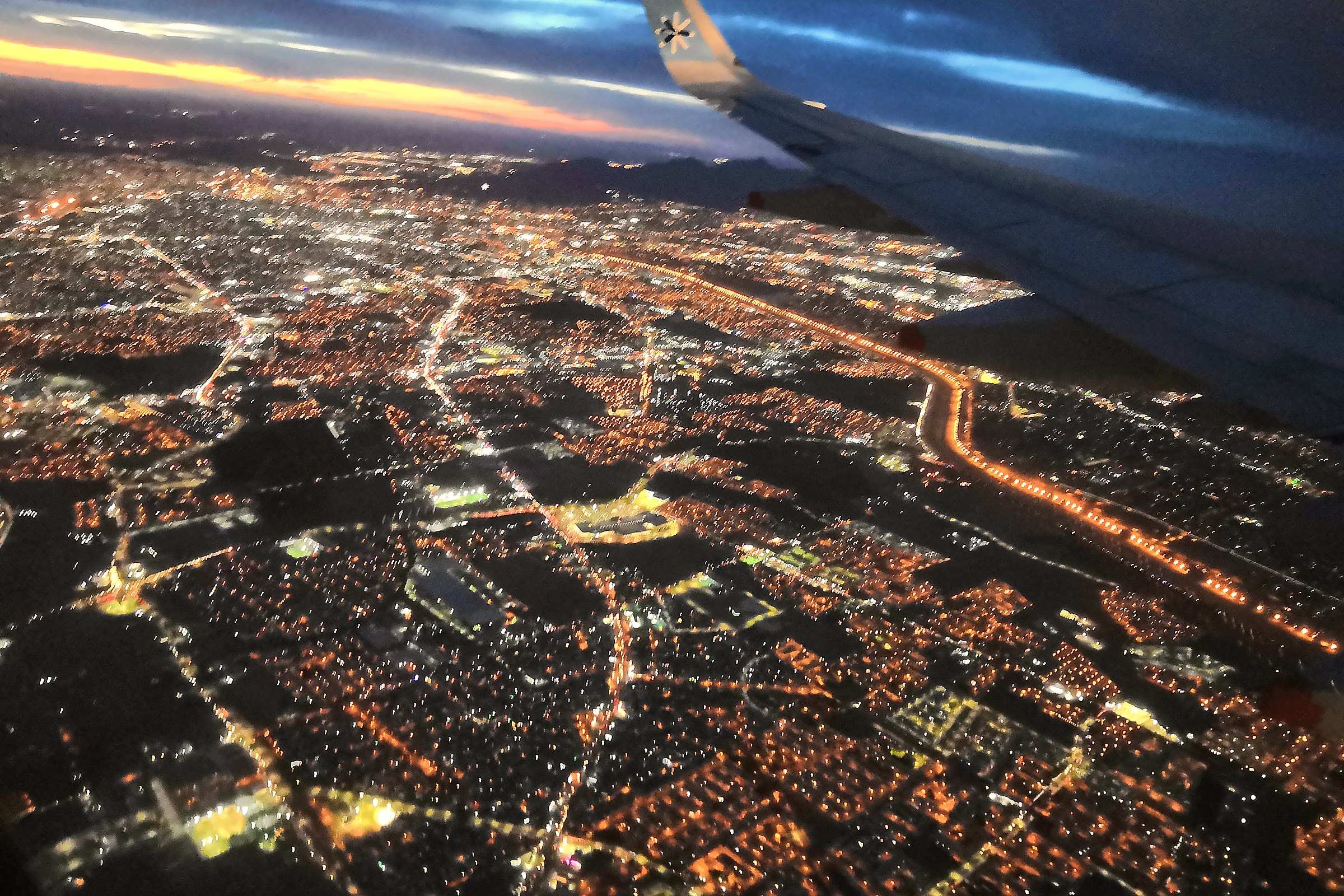 Ciudad Juárez at night from an airplane window, the city lights spread across the valley