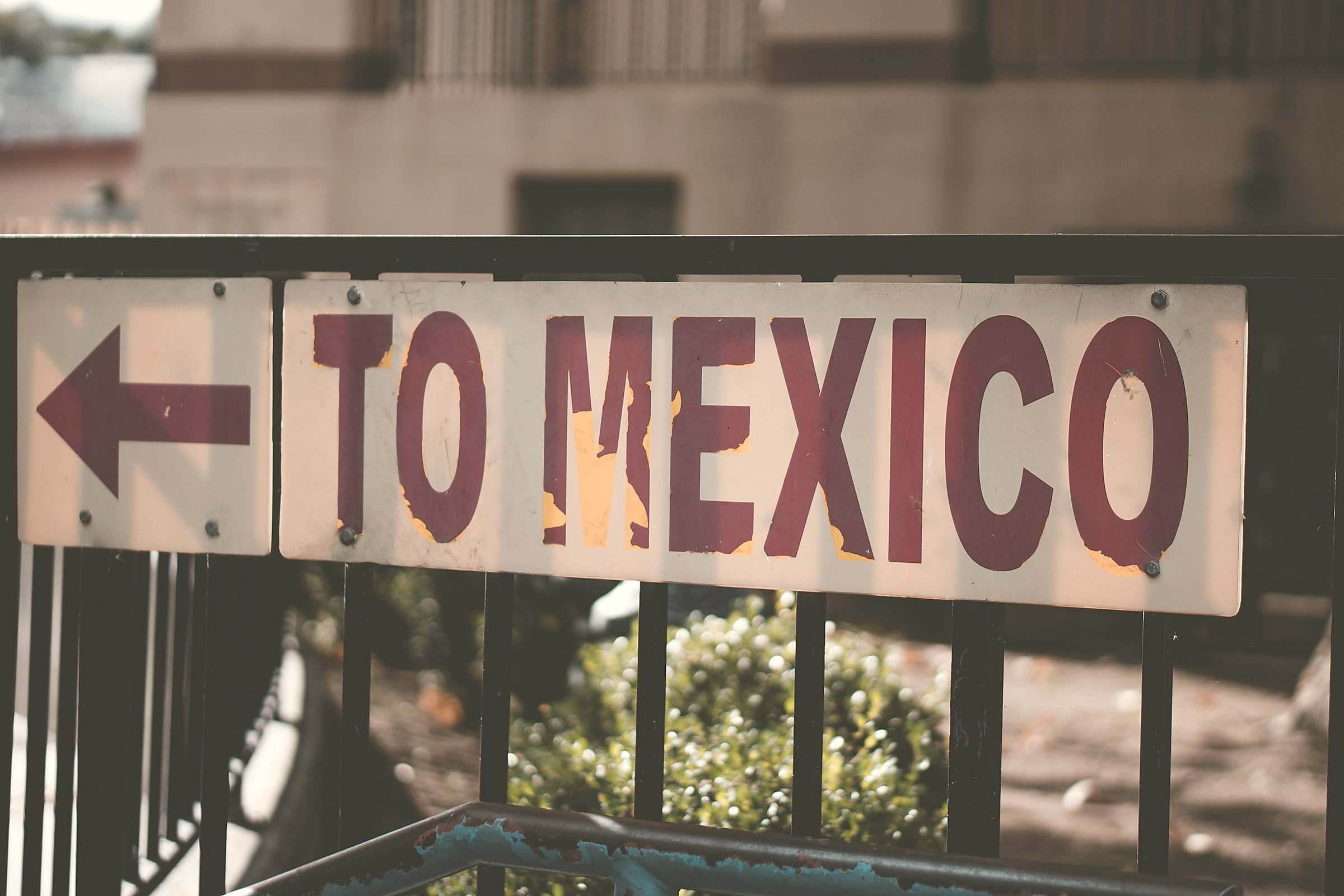 A weathered street sign with an arrow pointing the way "to Mexico"