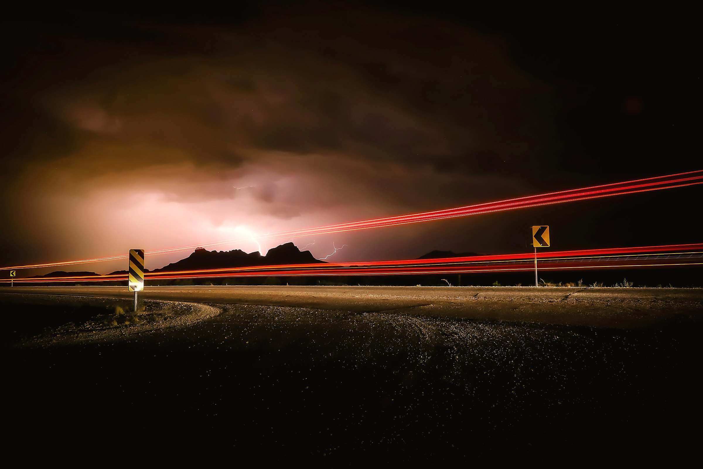 Lightning over the desert near Tucson, Arizona, with the light trails of cars on the highway