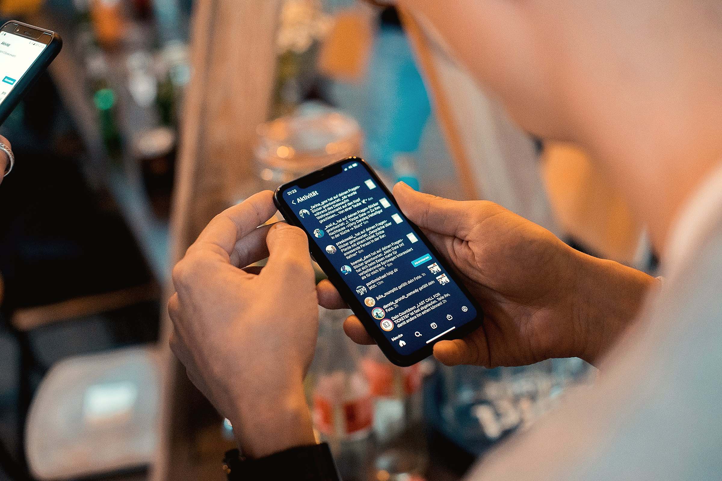 Two hands holding a smartphone open to a list of messages